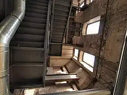 Turm innen, links das eingezogene Stahlgerüst, rechts das Mauerwerk, in der Ecke abgeschrägt eines der achteckigen Treppenhäuser mit Wendeltreppe (Blick nach oben).