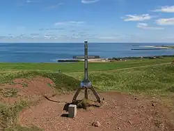 Das 1998 errichtete Gipfelkreuz. Heute ist dieser Teil des Oberlandes von Bombenkratern aus der Zeit bis zur Inselfreigabe 1952 geprägt. Er wurde nicht wie der bebaute Teil grundgeräumt. Es werden hier noch viele Blindgänger vermutet.