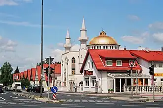 Moschee mit umgebender Architektur, im Vordergrund der türkische Imbiss