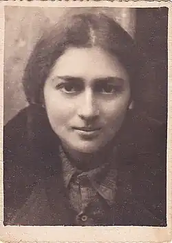 eine lächelnde junge Frau mit dunklen, ausdrucksvollen Augen; das Haar in der Mitte gescheitelt und zurückgebunden