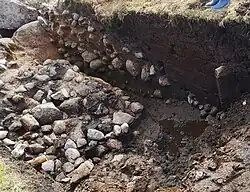 Steinpackung aus Geröllsteinen im Moorboden