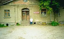 Vorderansicht des Gutshauses im August 1990. Deutlich zu erkennen ist die Tafel des (wenige Tage zuvor geschlossenen) Lebensmittelgeschäfts.