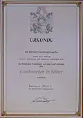 1983, 31. Mai. Urkunde. Die Kärntner Landesregierung verleiht Hans Pawlik, 3. Präsident des Kärntner Landtages a.&nbsp;D., den „Kärntner Landesorden in Silber“.