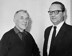 Schwarzweiß-Foto von Marc Chagall, einem älteren Mann mit weißem Haar, der lächelt, und Varian Fry, einem Mann mittleren Alters mit Brille und Anzug, die nebeneinander stehen.