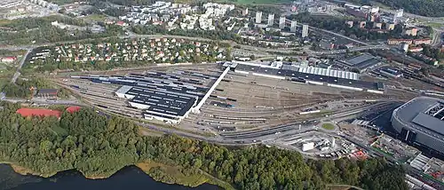 Der Bahnhof Hagalund im Jahr 2012, dahinter Ulriksdal und Råstahem, rechts die Friends Arena (Blick nach Norden)
