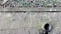 Hamburger Wappen von 1859 an der historischen Stützmauer der Poppenbüttler Schleuse.