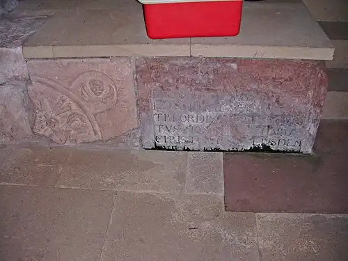 Spolien am Choraufgang in der Kirche. Rechts im Bild das Fragment des Grabsteins für Reichard Christoph Weickard, Sohn des Arnold Weickard, der als Leibarzt der Herzoginwitwe Anna Margaretha von Pfalz-Simmern-Sponheim (+ 1621) auf der Burg Neu-Bolanden wirkte.