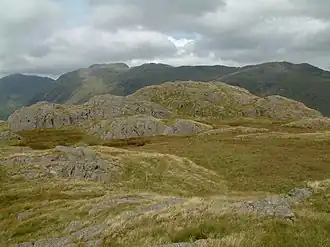 Der Gipfel des Hard Knott mit Crinkle Crags und Bowfell im Hintergrund