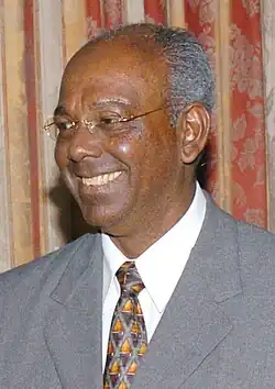 Ralph Ramkarran 2006; afro-amerikanischer Mann im grauen Anzug und grauen Haaren mit randloser Brille.