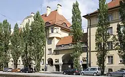 hinter einer Baumreihe stehen die vierstöckigen Wohnhäuser