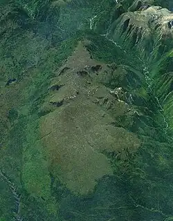 Ein großes, leicht vergletschertes Bergmassiv, von Vegetation und zwei Flüssen umgeben