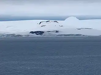 Blick von der McFarlane Strait auf den Hebrizelem Hill (vorn), den Tile Ridge (Mitte) und den verschneiten Mount Plymouth (Hintergrund)