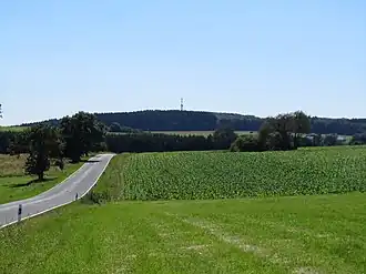 Blick von Nordnordosten zum Helleberg mit Aussichtsturm und Kreisstraße&nbsp;61 (Rotenhain–Wölferlingen)