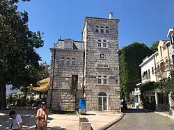 Der ehemalige Bahnhof von Herceg Novi am Hafen ist heute ein Bed and Breakfast und ein Restaurant – der Stationsname ist noch am Gebäude vorhanden, in kyrillischer Schrift