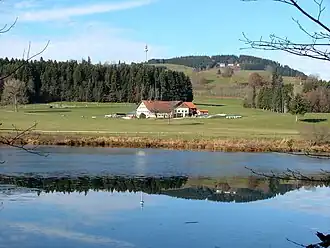 Blick über den Herrenwieser Weiher hinweg und vorbei am Einödhof Herrenwies nordwestwärts zum Blender