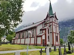 Foto einer Holzkirche in bergiger Umgebung
