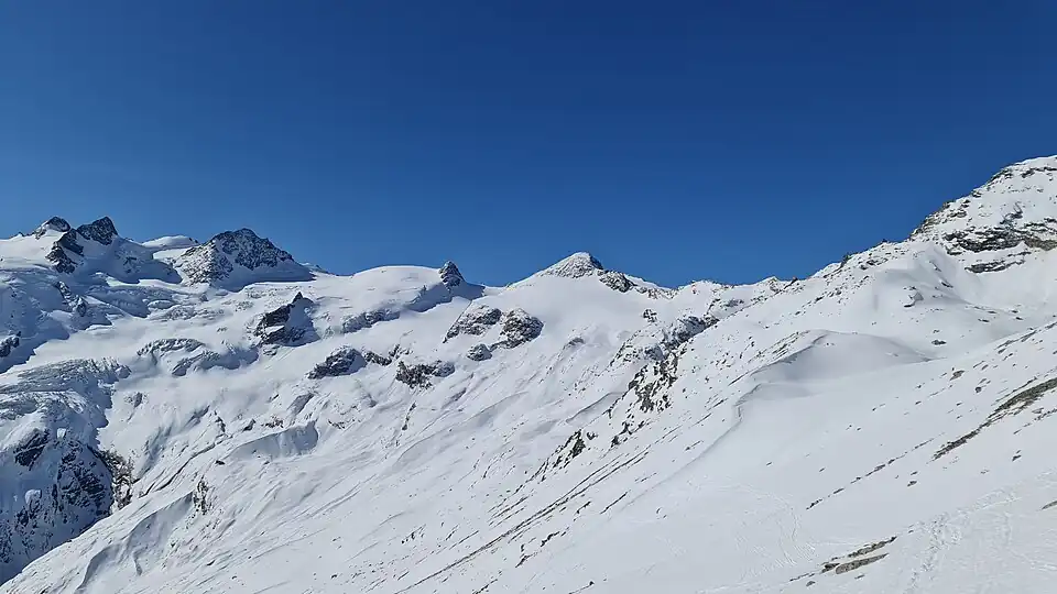Punta Orientale della Sella, Punta Occidentale della Sella, Cima Sondrio, Piz Glüschaint, La Muongia und Il Chapütschin (v.&nbsp;l.&nbsp;n.&nbsp;r.), aufgenommen von Murtèl Sur (für Annotationen der einzelnen Berge aufs Bild klicken)