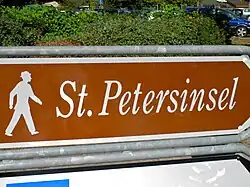 Ein touristischer Wegweiser für Fußgänger in der Schweiz zu einer Insel im Bielersee