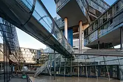 Gläserne Verbindungsgänge und künstlicher See. Unter dem Turm sind die beiden Stützen sichtbar.