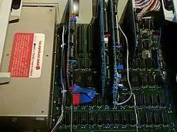 Netzteil, daneben die Steckkarten: Speicher­erweiterung 16&nbsp;KB („Apple II Language Card“), Karte mit einem Z80-Prozessor, 80-Zeichen-Karte und Karte für Floppy-Disk-Laufwerke