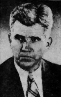 Mann im mittleren Alter von vorn ab Schulterblatt im dunklen Jackett, weißem Hemd und Krawatte in schwarzweiß.