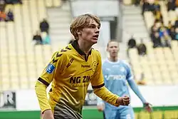 Jeppe Kjær, blonde Haare im Fassonschnitt, und in orange-gelben Trikot, bei seinem Superligadebüt in der Casa Arena Horsens im Stadion des Randers FC.