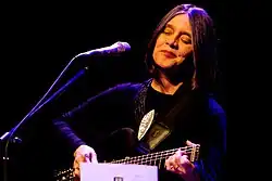 Joyce Moreno mit Scheitelfrisur bei einem Auftritt 2010, Augen geschlossen, ein Saiteninstrument spielend