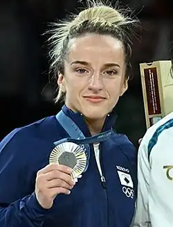Krasniqi in blauer Trainingsjacke präsentiert ihre Silbermedaille.