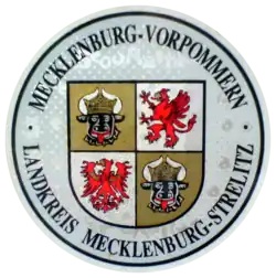 Zulassungsplakette des Landkreises Mecklenburg-Strelitz mit dem mecklen­burg-vorpommer­schen Landeswap­pen bis 2011