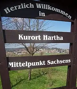 Blick durch die Begrüßungstafel auf den Ort