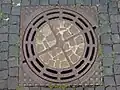 „Hannover 1899“ datierter Kanaldeckel im Maschpark, an der Südostecke des Neuen Rathauses, hier noch ohne den Zusatz als Aktiengesellschaft