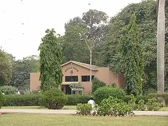 Ein braunes Haus, das links und rechts von Bäumen umgeben ist.