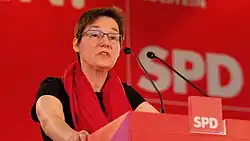Porträt von Karin Thissen vor rotem Hintergrund mit SPD Logo