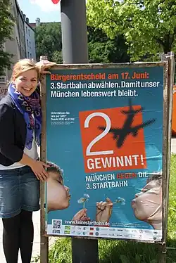 Katharina Schulze präsentiert das Plakat zum Bürgerentscheid über die Dritte Startbahn am Münchner Flughafen