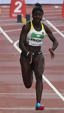 Dieses Farbfoto zeigte die deutsche Sprinterin Keshia B. Kwadwo in Sportkleidung nebst Tshirt des Turnierveranstalters im Lauf auf einer Aschenbahn von vorne und wurde 2018 aufgenommen.