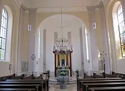 Blick in den Chorraum mit modernem Altar, Taufstein und neuer Kanzel