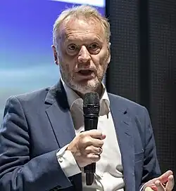 Foto eines Mannes, der in ein Mikrofon spricht