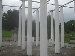 Stangenwald, Nordwestecke mit Betonstühlen und Blumenschale.