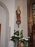 Im Mai geschmückte Marienstatue am linken Chorpfeiler
