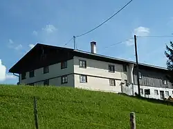 zweigeschossiger, verschindelter Einfirsthof mit Flachsatteldach