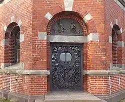 Haupteingang auf der Ostseite, oben Relief der Nord-Ostsee-Meerjungfrauen.