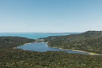 Lower Nihotupu Reservoir und Manukau Harbour im Hintergrund