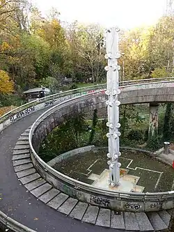 Ludwig Stocker (* 1932), Bildhauer. Stele aus Carrara-Marmor, Ein- und Ausrollen, 1978. Galgenhügel Promenade, Basel, Auftrag Kunstkredit Basel-Stadt