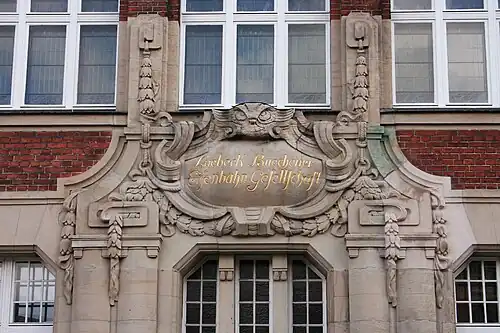 Inschriften-Kartusche über dem Portal