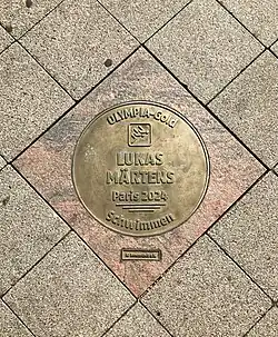 Plakette für Lukas Märtens, umgeben vom Straßenpflaster
