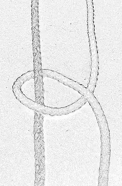 Mit dem Arbeitsfaden ein Halber Schlag um den Tragfaden nach links gehend gelegt.