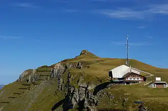 Blick vom Berghaus Männlichen hinauf zum Gipfel. Im Vordergrund die Bergstation der Luftseilbahn Wengen–Männlichen.