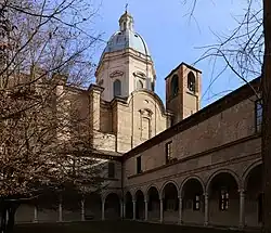 Erhaltener Teil des Kreuzgangs mit der dahinter angrenzenden Kirche