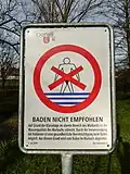 Warnschild mit Warnung für das Unterlassen des Badens im Marchbach aufgrund von Abwasserverschmutzung beim Eisweiher in Oberwil