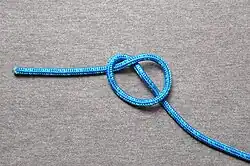 … und nach unten geklappt und das ziehende Ende (bei Strickleiter nach oben zeigend) unter das Auge legen.